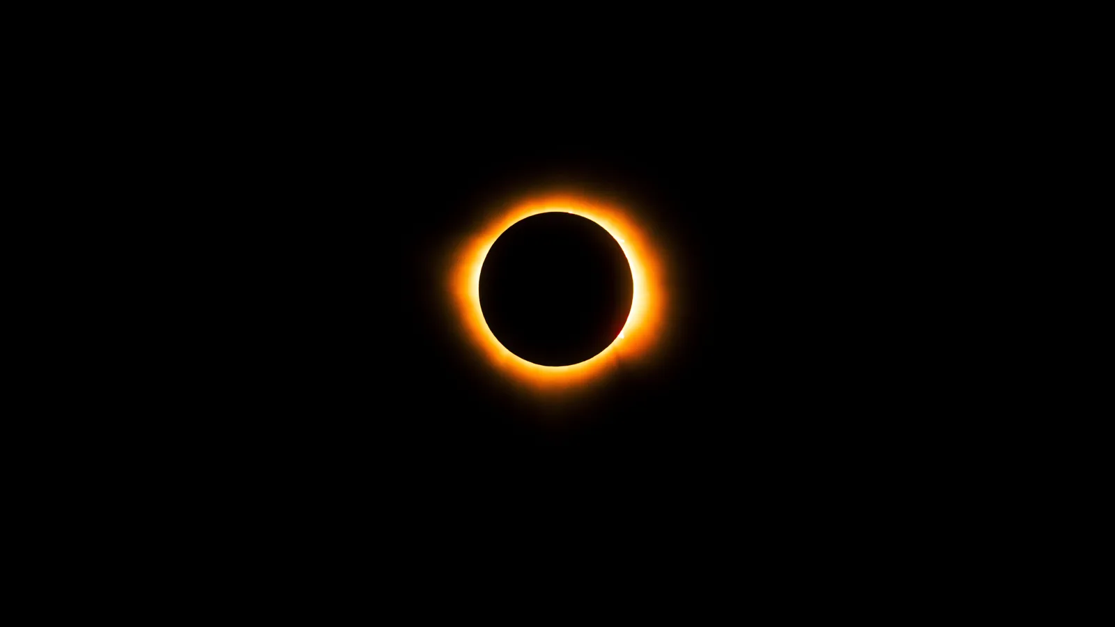 Zonsverduistering waarbij een dunne oranje ring van zonlicht rond de zwarte maanschijf zichtbaar blijft